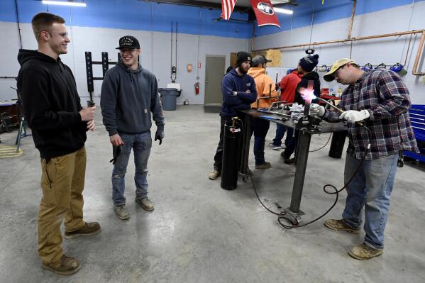 Payton Lane, 19, left, and Boone Williams, 20, talk during a second-year apprentice training program class at the Plumbers and Pipefitters Local Union 572 facility in Nashville, Tenn., on Thursday, Feb. 2, 2023. The union is working with young adults who graduated from high school during the pandemic and are taking career routes other than college for its apprentice program. (AP Photo/Mark Zaleski)