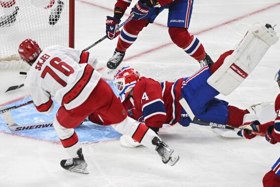 Montreal Canadiens goaltender Jake Allen gives up a goal to Carolina Hurricanes' Brady Skjei (76) during the second period of an NHL hockey game Tuesday, March 7, 2023, in Montreal. (Graham Hughes/The Canadian Press via AP)