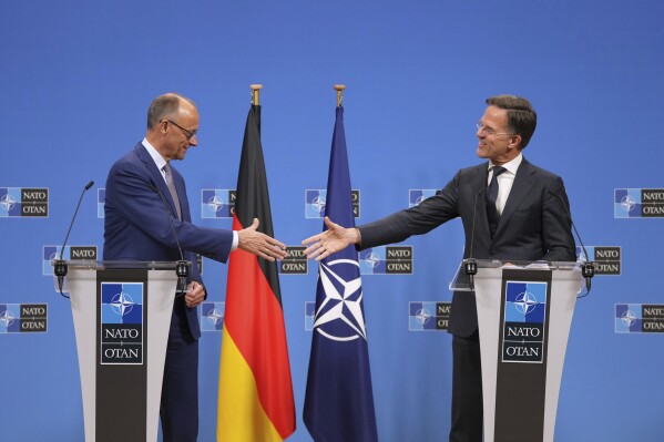Germany's Chancellor Friedrich Merz, left, shakes hands with NATO Secretary General Mark Rutte during a media conferenc6 at NATO headquarters in Brussels, Friday, May 9, 2025. (AP Photo/Virginia Mayo)
