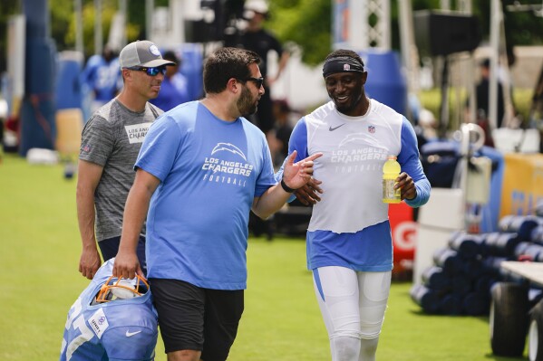 Los Angeles Chargers cornerback J.C. Jackson, right, speaks with a support staff member during the NFL football team's training camp, Monday, July 31, 2023, in Costa Mesa, Calif. (AP Photo/Ryan Sun)