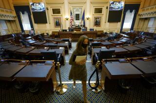 FILE - This Wednesday Feb. 10, 2021 file photo shows House speaker Del. Eileen Filler-Corn, D-Fairfax, as she exits the center isle of the empty Virginia House of Delegates chamber after a Zoom Legislative session at the Capitol in Richmond, Va. Lawmakers are set to convene at the Capitol in Richmond for a short special session to elect judges and allocate Virginia's $4.3 billion share of the latest federal coronavirus relief bill. (AP Photo/Steve Helber)