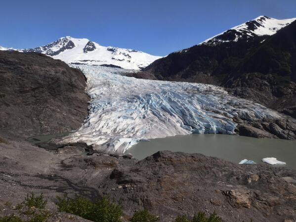 FILE - Chunks of ice float on Mendenhall Lake in front of the Mendenhall Glacier on Monday, May 30, 2022, in Juneau, Alaska. A study of all of the world's 215,000 glaciers published on Thursday, Jan. 5, 2023, finds even if with the unlikely minimum warming of only a few tenths of a degrees more, the world will lose nearly half its glaciers by the end of the century. With the warming we're now on track to get, the world will lose two-thirds of its glaciers and overall glacier mass will drop by one-third while sea level rises 4.5 inches just from melting glaciers. (AP Photo/Becky Bohrer)