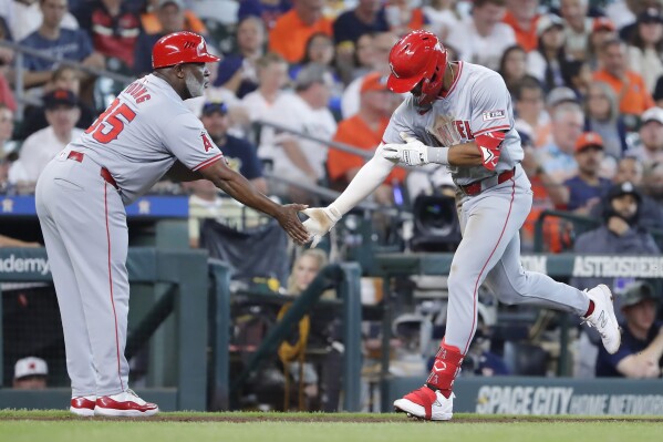 Los Angeles Angels third base coach Eric Young Sr., left, and Kyren Paris, right, celebrate the two-run home run by Paris as he rounds the bases against the Houston Astros during the fifth inning of a baseball game Wednesday, May 22, 2024, in Houston. (AP Photo/Michael Wyke)