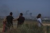 People watch smoke rising to the sky after an explosion in the Gaza Strip, as seen from southern Israel, Friday, May 17, 2024. (AP Photo/Tsafrir Abayov)