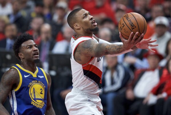 FILE - In this May 20, 2019, file photo, Portland Trail Blazers guard Damian Lillard, right, shoots near Golden State Warriors forward Jordan Bell during the first half of Game 4 of the NBA basketball playoffs Western Conference finals in Portland, Ore. (AP Photo/Craig Mitchelldyer, File)