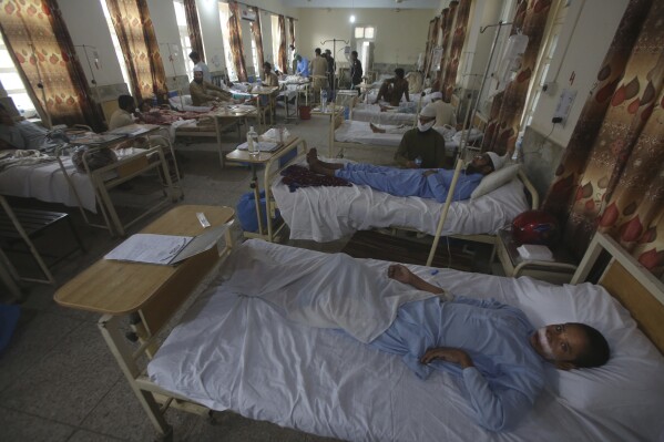 Injured people lie on the bed at a hospital after Sunday's suicide bomber attack, in the Bajur district of Khyber Pakhtunkhwa, Pakistan, Monday, July 31, 2023. Pakistan held funerals on Monday for victims of a massive suicide bombing that targeted a rally of a pro-Taliban cleric the previous day. (AP Photo/Mohammad Sajjad)