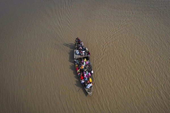 FILE-People cross the Brahmaputra river in a boat to reach a polling booth during the second round of voting in the six-week-long national election in Morigaon district, Assam, India, Friday, April 26, 2024. (AP Photo/Anupam Nath,file)