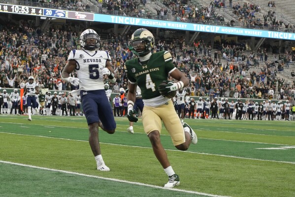 ADDS NEVADA DEFENSIVE BACK EMANY JOHNSON (5) - Colorado State wide receiver Louis Brown IV (4) runs into the end zone for a touchdown after catching a pass in front of Nevada defensive back Emany Johnson (5) in the second half of an NCAA college football game Saturday, Nov. 18, 2023, in Fort Collins, Colo. (AP Photo/David Zalubowski)