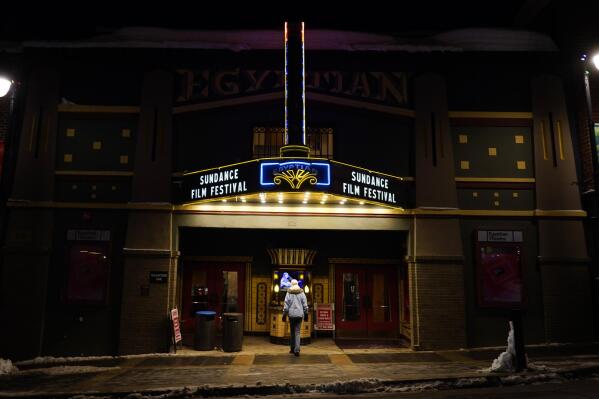 A pedestrian peers into the ticket booth of the Egyptian Theatre before the start of the 2023 Sundance Film Festival, Wednesday, Jan. 18, 2023, in Park City, Utah. The annual independent film festival runs from Jan. 19-29. (AP Photo/Chris Pizzello)