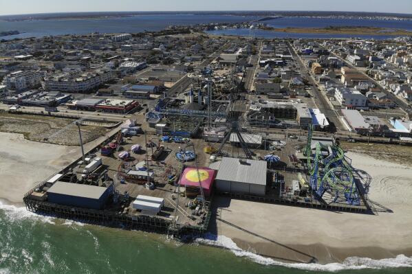 An amusement park sits next to the ocean in Seaside Heights, N.J., Thursday, Oct. 20, 2022. The Jet Star roller coaster, whose collapse into the ocean at Seaside Heights, N.J. during Sandy provided an iconic image of the storm's destruction, has been replaced with a new ride, built on the beach instead of over the water like its predecessor. (AP Photo/Seth Wenig)