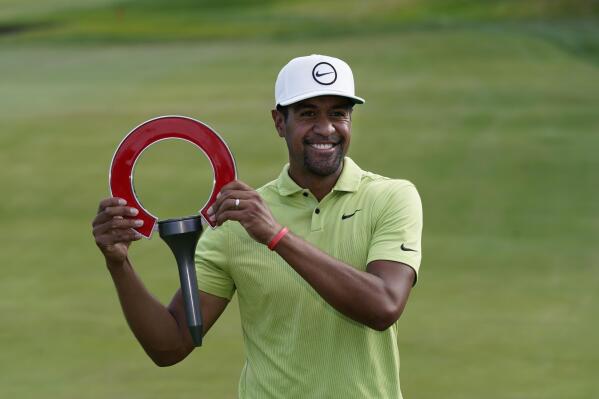 Tony Finau holds the winner's trophy after the final round of the Rocket Mortgage Classic golf tournament, Sunday, July 31, 2022, in Detroit. (AP Photo/Carlos Osorio)