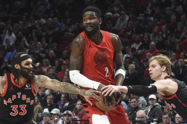 Toronto Raptors guard Gary Trent Jr. (33) and guard Gradey Dick, right, reach in on Portland Trail Blazers center Deandre Ayton (2) during the first half of an NBA basketball game in Portland, Ore., Saturday, March 9, 2024. (AP Photo/Steve Dykes)