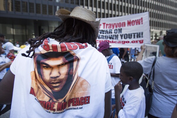 FILE - A woman with a shirt with Trayvon Martin's face on it that reads "No Justice, No Peace" stands at the "Justice for Trayvon" rally in Chicago, July 20, 2013. The Black Lives Matter movement hits a milestone on Thursday, July 13, 2023, marking 10 years since its 2013 founding in response to the acquittal of the man who fatally shot Martin. (AP Photo/Scott Eisen, File)