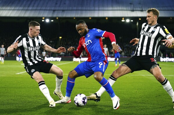 Crystal Palace's Jordan Ayew, centre, vies for the ball with Newcastle United's Elliot Anderson, left and Dan Burn , during the English Premier League soccer match between Crystal Palace and Newcastle United, at Selhurst Park, London, Wednesday April 24, 2024. (John Walton/PA via AP)