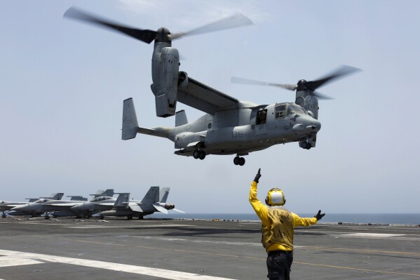 In this image provided by the U.S. Navy, Aviation Boatswain's Mate 2nd Class Nicholas Hawkins signals an MV-22 Osprey to land on the flight deck of the USS Abraham Lincoln in the Arabian Sea on May 17, 2019. Families of four of the five Marines killed when their MV-22 Osprey tiltrotor aircraft crashed in California in June of 2022 filed a federal lawsuit Thursday, May 23, 2024, alleging that the Osprey's manufacturers failed to address known mechanical failures with the airframe. (Mass Communication Specialist 3rd Class Amber Smalley/U.S. Navy via AP)