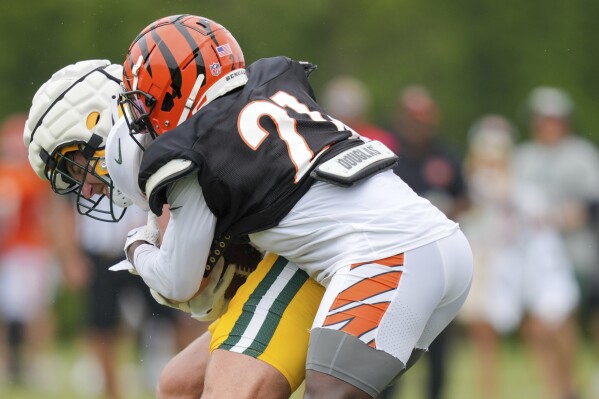 Green Bay Packers tight end Luke Musgrave, left, makes a catch against Cincinnati Bengals cornerback Mike Hilton during a joint practice at the NFL football team's training facility in Cincinnati, Wednesday, Aug. 9, 2023. (AP Photo/Aaron Doster)