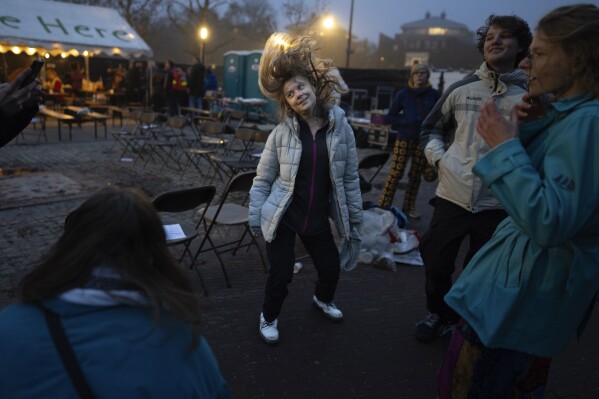 Climate activist Greta Thunberg dances after addressing tens of thousands of people who marched through Amsterdam, Netherlands, Sunday, Nov. 12, 2023, to call for more action to tackle climate change. (AP Photo/Peter Dejong)