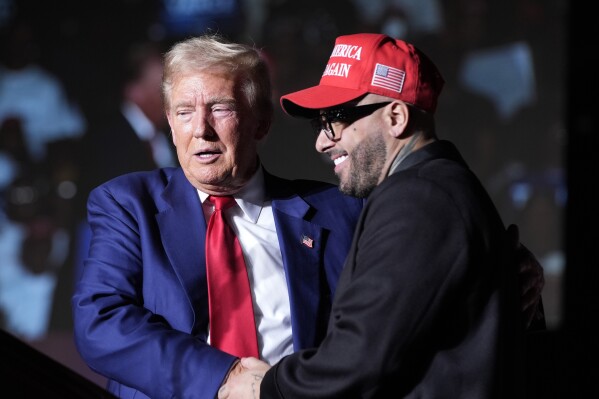 Republican presidential nominee former President Donald Trump, left, greets Nicky Jam during a campaign event at the World Market Center, Friday, Sept.13, 2024, in Las Vegas. (AP Photo/Alex Brandon)