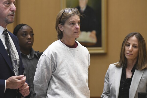Michelle Troconis stands in Connecticut Superior Court at the start of her sentencing hearing in Stamford, Conn., Friday, May 31, 2024. Troconis, convicted of helping her boyfriend plot and cover up the murder of his estranged wife, Jennifer Dulos, was sentenced to 20 years in prison. (Ned Gerard/Hearst Connecticut Media via AP, Pool)