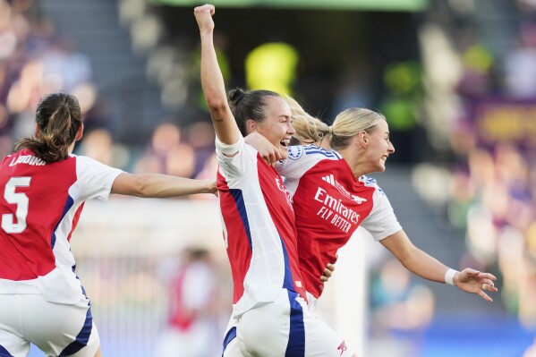 Arsenal's Caitlin Foord, center, and Chloe Kelly, right, celebrate after winning the women's Champions League final soccer match between Arsenal and FC Barcelona at the Jose Alvalade Stadium in Lisbon, Saturday, May 24, 2025. (AP Photo/Jose Breton)