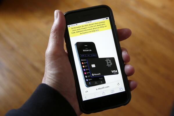 FILE - Text, in yellow, announcing cryptocurrency lender BlockFi's bankruptcy filing, appears on the company's website on a smartphone, Nov. 28, 2022, in New York. Over the past few years, a number of companies have attempted to act as the cryptocurrency equivalent of a bank, promising lucrative returns to customers who deposited their bitcoin or other digital assets. In a span of less than 12 months, nearly all of the biggest of those companies have failed spectacularly. (AP Photo/Peter Morgan, File)