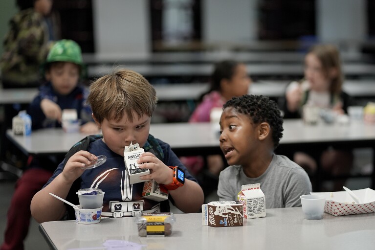 First graders Ripley Phillips, left, and Jabari Hall talk during breakfast at Williams Science and Arts Magnet school Friday, May 10, 2024, in Topeka, Kan. The school is just a block from the former Monroe school which was at the center of the Brown v. Board of Education Supreme Court ruling ending segregation in public schools 70 years ago. (AP Photo/Charlie Riedel)