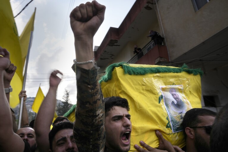 FILE - A Hezbollah fighter carries the coffin of his comrade who was killed by Israeli shelling, as he shouts slogans during his funeral procession in Kherbet Selem village, south Lebanon, Tuesday, Oct. 10, 2023. (AP Photo/Hussein Malla, File)