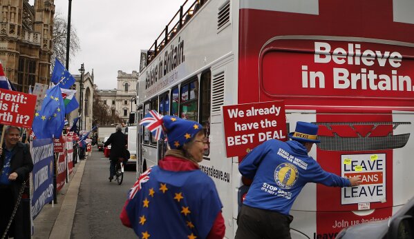 
              Anti Brexit demonstrators put stickers on a bus during a protest outside the Houses of Parliament in London Thursday Dec. 6, 2018.  Britain's Prime Minister Theresa May's effort to win support for her Brexit agreement comes amid reports in British newspapers Thursday, predicting that Parliament could reject the deal by more than 100 votes. (AP Photo/Frank Augstein)
            