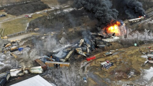 FILE - In this photo taken with a drone, portions of a Norfolk Southern freight train that derailed the previous night in East Palestine, Ohio, remain on fire at mid-day, Feb. 4, 2023. Norfolk Southern says the owner of the rail car that caused the fiery Ohio derailment in February failed to properly maintain it in the years before the crash, and the railroad wants to make sure that company and the owners of the other cars involved pay their fair share of the costs. The railroad filed a complaint Friday, June 30, against all the car owners and shippers responsible for the hazardous chemicals that spilled in the derailment. (AP Photo/Gene J. Puskar, File)