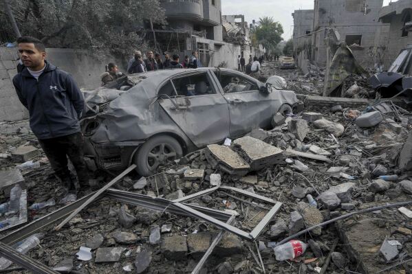 Palestinians inspect the rubble of a building of the Al Nawasrah family destroyed in an Israeli strike in Maghazi refugee camp, central Gaza Strip, Monday, Dec. 25, 2023. (AP Photo/Adel Hana)