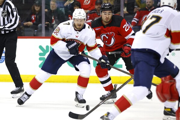 Florida Panthers defenseman Dmitry Kulikov (7) battles New Jersey Devils right wing Timo Meier (28) for the puck during the second period of an NHL hockey game, Tuesday, March 5, 2024, in Newark, N.J. (AP Photo/Noah K. Murray)
