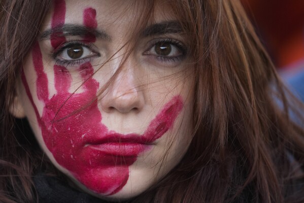 A woman attends a demonstration on the occasion of International Day for the Elimination of Violence against Women, in Milan, Italy, Saturday, Nov. 25, 2023. (AP Photo/Luca Bruno)