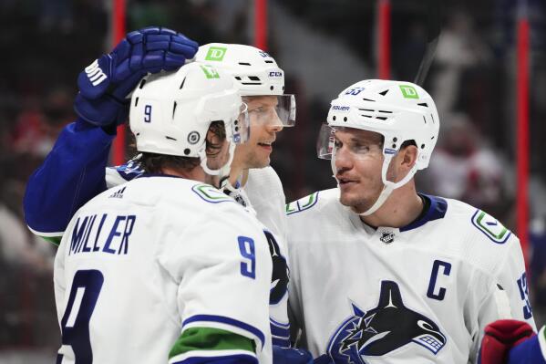 Vancouver Canucks center J.T. Miller (9), and teammates Alex Chiasson (39) and Bo Horvat (53) celebrate a goal against the Ottawa Senators during the third period of an NHL hockey game, Wednesday, Dec.1, 2021 in Ottawa, Ontario. (Sean Kilpatrick/The Canadian Press via AP)