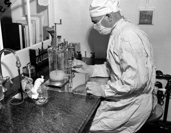 FILE - In this Dec. 2, 1947 file photo, Charles D. Brown, fills a vial with the BCG tuberculosis vaccine, at a state-operated laboratory in Albany, N.Y. Scientists are dusting off some decades-old vaccines against TB and polio to see if they could provide stopgap protection against COVID-19 until a more precise shot arrives.  (AP Photo)