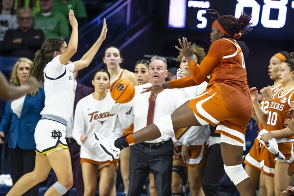 Texas forward Kyla Oldacre,front right, throws the ball toward Notre Dame guard Sonia Citron, front left, as she falls out of bounds during overtime of an NCAA college basketball game Thursday, Dec. 5, 2024, in South Bend, Ind. (AP Photo/Michael Caterina, File)