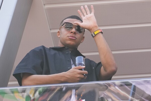 Kylian Mbappe waves from a terrace before the Formula One Monaco Grand Prix race at the Monaco racetrack, in Monaco, Sunday, May 26, 2024. (AP Photo/Luca Bruno)