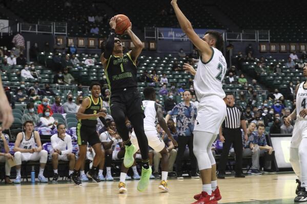 South Florida guard Javon Greene (1) shoots over Hawaii forward Jerome Desrosiers (22) during the first half of an NCAA college basketball game Thursday, Dec. 23, 2021, in Honolulu. (AP Photo/Marco Garcia)