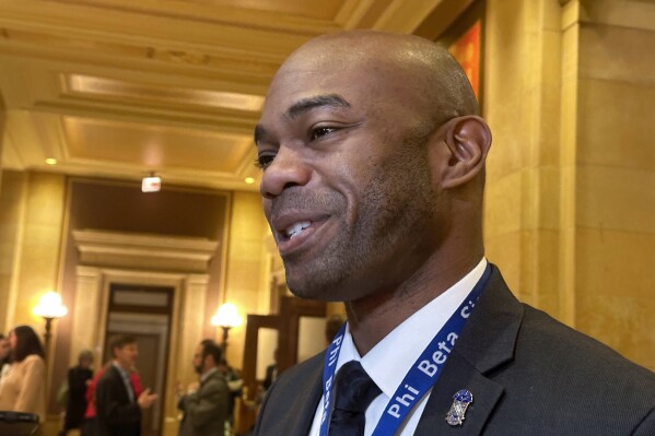Democratic Minnesota State Rep. Cedrick Frazier, of New Hope, speaks with reporters at the State Capitol on Monday, March 4, 2024, in St. Paul, Minn., ahead of a debate on his bill to clarify the powers of police officers who work in schools. (AP Photo/Steve Karnowski)