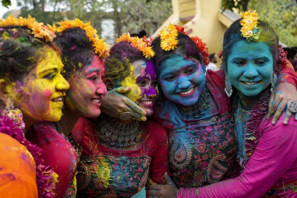 Women, with their faces smeared with coloured powder, pose for a photograph as they celebrate Holi, the festival of colors, in Kolkata, India, Monday, March 25, 2024. (AP Photo/Bikas Das)