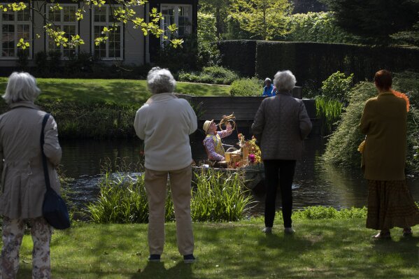 Reinier Sijpkens performs classical music on his music boat for elderly people confined to their nursing home because of the coronavirus on King's Day in Heemstede, Netherlands, Monday, April 27, 2020. The Dutch national birthday party was a muted affair, dubbed King's Day at Home because of coronavirus restriction, a far cry usual nationwide celebration with street parties. (AP Photo/Peter Dejong)