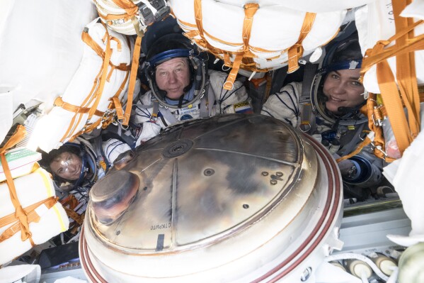 NASA's Loral O'Hara, left, Russia’s Oleg Novitsky and Belarus spaceflight participant Marina Vasilevskaya, right, are seen inside the Soyuz MS-24 spacecraft after they landed in a remote area near the town of Dzhezkazgan, Kazakhstan, Saturday, April 6, 2024. (Bill Ingalls/NASA via AP)