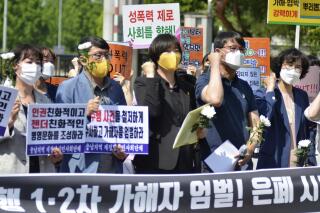 Members of the Justice Party and civic groups attend at a press conference calling for the punishment of air force officials involved in any cover-up, in front of the main gate of air force base in Seosan, South Korea, Friday, June 4, 2021. South Korea’s air force chief stepped down Friday in the face of public anger over the death of a female master sergeant whose family says she killed herself after being sexually abused by a male colleague.  A part of letters read "Punishment! and Cover-up."(Lee Eun-pa/Yonhap via AP)