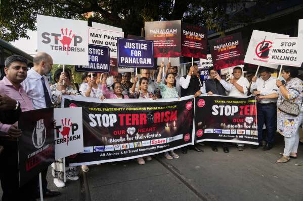 Members of airlines and tourism facility providers walk in a procession with posters during a protest against the killing of tourists by militants near Pahalgam in Indian controlled Kashmir, in Kolkata, India, Thursday, April 24, 2025. (AP Photo/Bikas Das)
