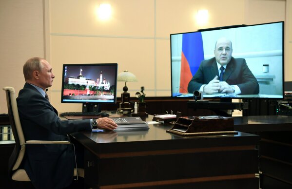 Russian President Vladimir Putin, left, attends a meeting with Russian Prime Minister Mikhail Mishustin via teleconference at the Novo-Ogaryovo residence outside Moscow, Russia, Tuesday, June 2, 2020. Putin instructed his government to take quick steps to repair economic damage from the coronavirus pandemic. (Alexei Nikolsky, Sputnik, Kremlin Pool Photo via AP)