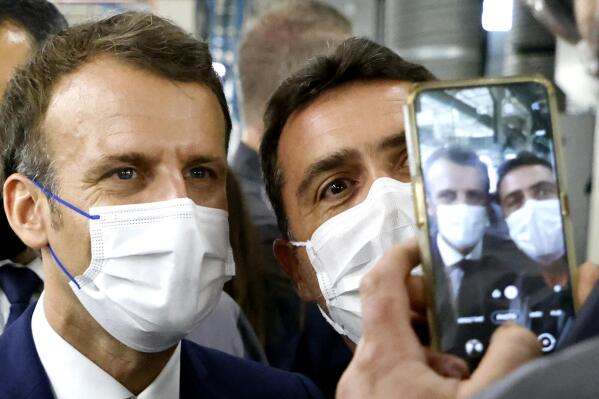 French President Emmanuel Macron, left, poses for a selfie as he visits the site of the future factory of battery maker Envision AESC group, where French car marker Renault develops an electric-vehicle manufacturing hub, in Douai, northern France, Monday June 28, 2021. Mainstream candidates delivered a stinging setback to France's far right in regional elections Sunday. (Ludovic Marin, Pool Photo via AP)