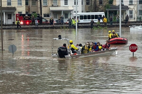 In a photo provided by Alley and Tim Wade, students are being rescued by boat after flash flooding in Westernport, MD., Tuesday, May 13, 2025. (Alley and Tim Wade via AP)