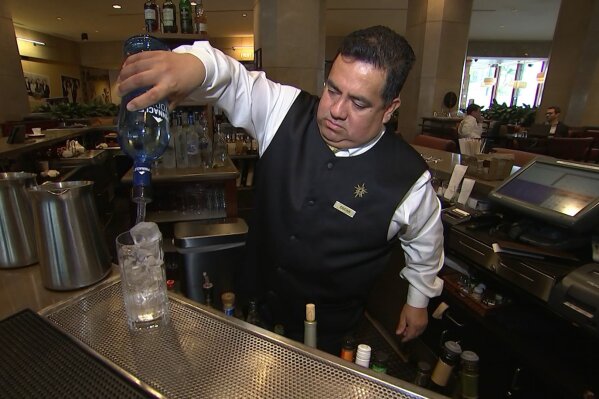 
              This Jan. 3, 2017 image taken from video shows Beverly Hilton hotel bartender Oscar Zuleta mixing drinks at the hotel in Beverly Hills, Calif. Zuleta has toasted with Sean Connery, gotten a head rub from Tom Hanks, shared a selfie with Jessica Alba while working previous Golden Globe Awards. The 48-year-old hotel staffer keeps the drinks flowing at the awards circuit's booziest gathering. (AP Photo/Rick Taber)
            