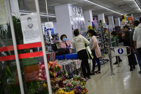 A woman wears a mask to face costumers to prevent coronavirus, in Pamplona, northern Spain, Thursday, March 12, 2020. For most people, the new COVID-19 coronavirus causes only mild or moderate symptoms, such as fever and cough, but for some, especially older adults and people with existing health problems, it can cause more severe illness, including pneumonia.  (AP Photo/Alvaro Barrientos)