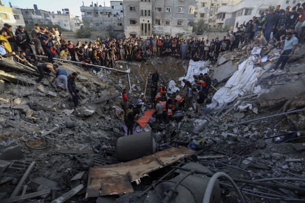 Palestinians gather over the remains of a destroyed house following Israeli airstrikes on Gaza City, Saturday, Oct. 21, 2023. (AP Photo/Abed Khaled)