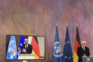 German President Frank-Walter Steinmeier, right, and Director General of the World Health Organization Tedros Adhanom Ghebreyesus, left on the screen, brief the media on a virtual joint news conference at Bellevue Palace in Berlin, Germany, Monday, Feb. 22, 2021. (AP Photo/Markus Schreiber)